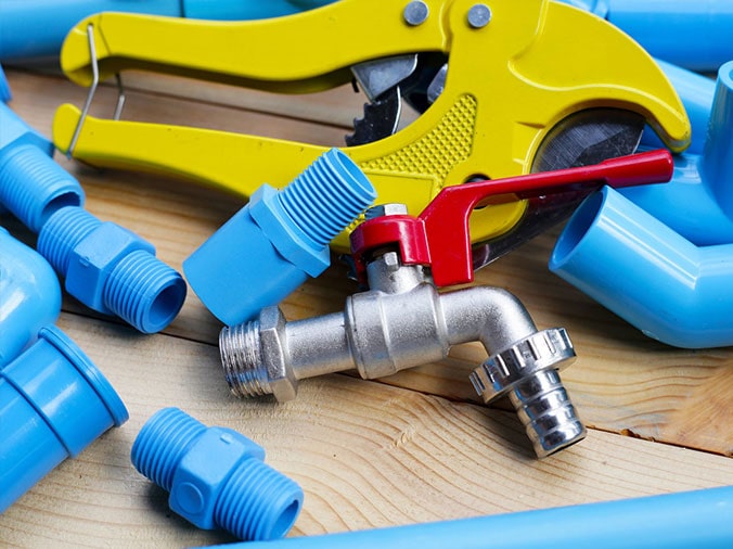 Blue PVC pipe fittings with a PVC cutting tool